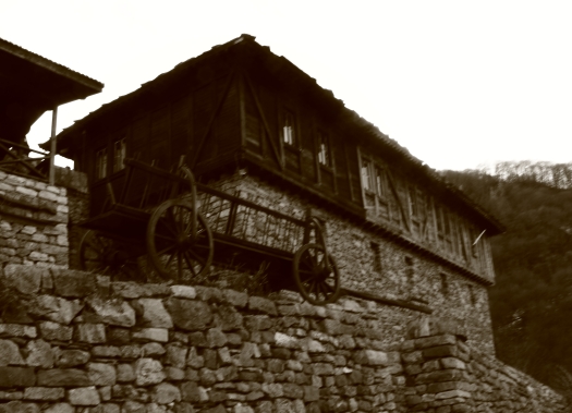 old building and wooden cart perched on rock